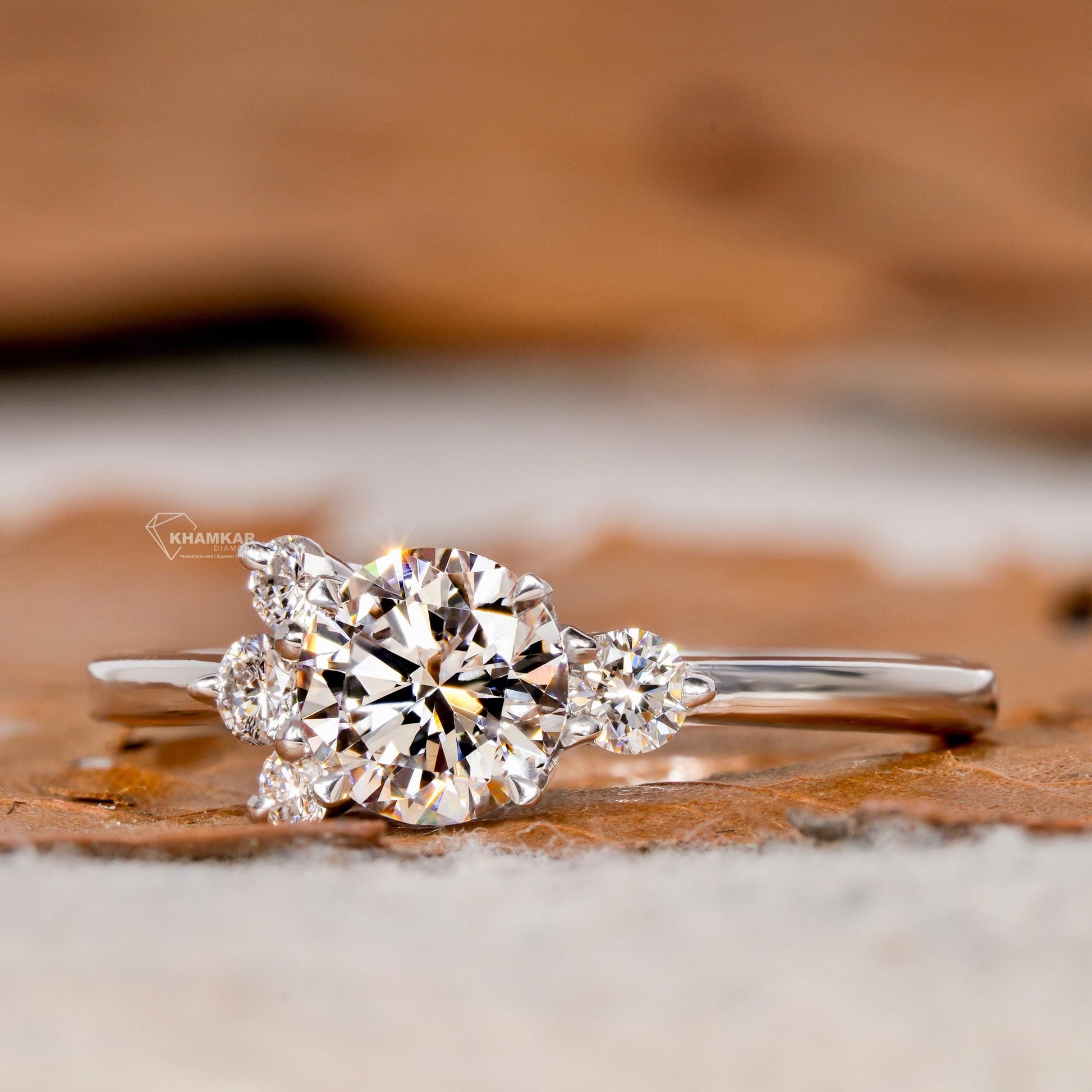 Engagement ring with white metal, round center stone, round accent diamonds in a cluster setting, front view
