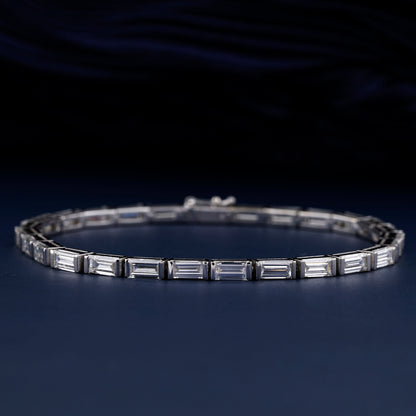 Bracelet with white metal links, rectangular step-cut stones in tennis bracelet design, oval display, angled front view on a dark background
