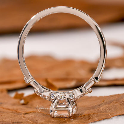 Engagement ring with white metal band, emerald-cut clear center stone, open gallery setting and rear profile view
