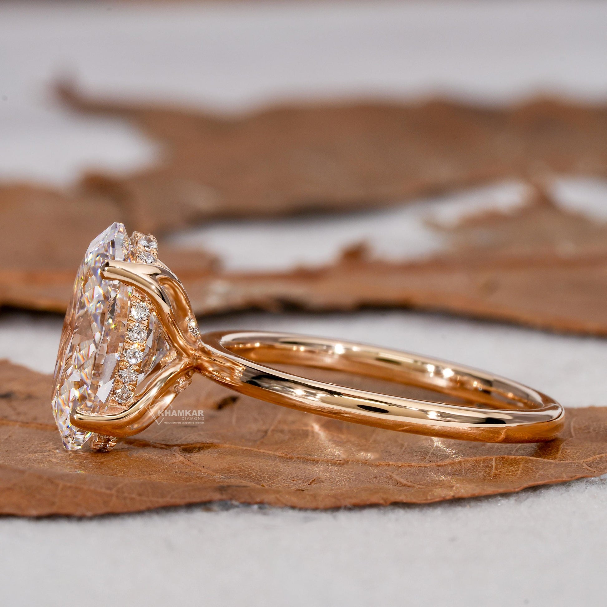 Engagement ring with yellow metal band, oval solitaire gemstone, pavé accent setting and split shank design, side view
