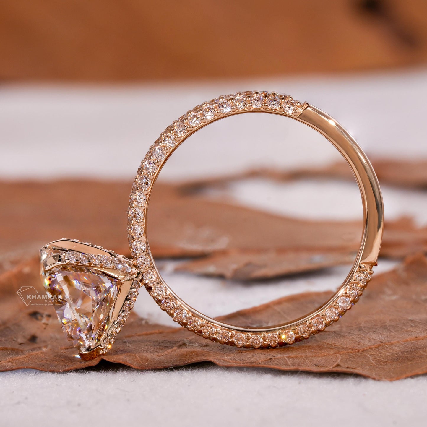 Engagement ring with rectangular clear gemstone, yellow metal pavé band, cathedral setting, side profile view
