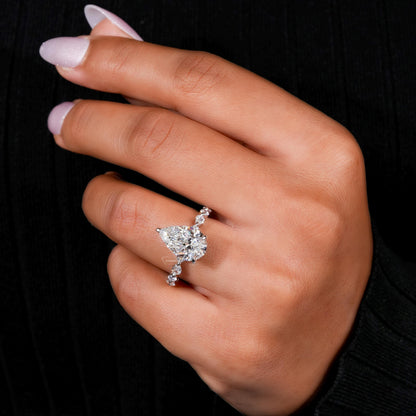Engagement ring with polished white metal band, heart-shaped clear gemstone and round accent stones, worn on finger, angled view
