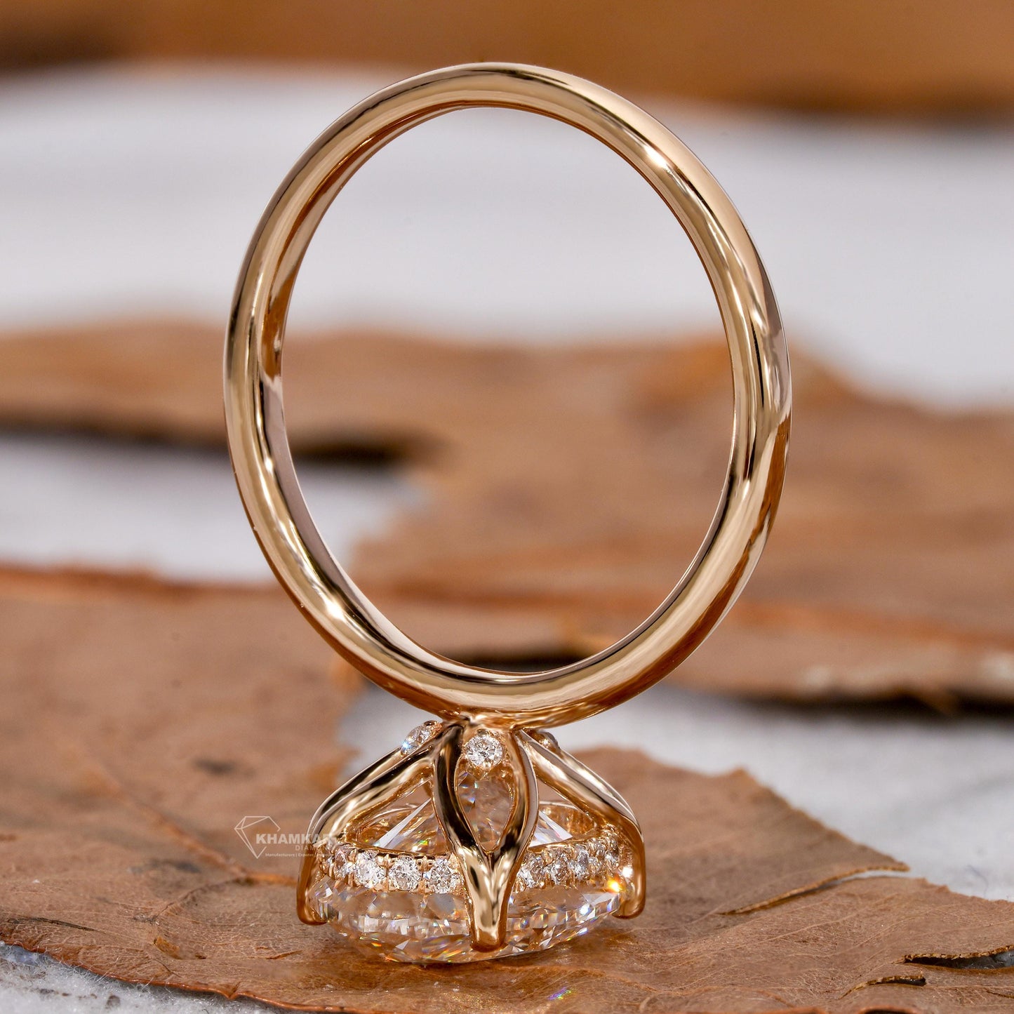 Engagement ring with yellow metal band, oval solitaire gemstone, pavé accent gallery and open basket setting, rear view
