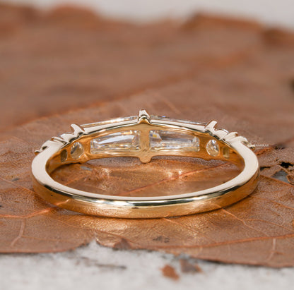 Engagement ring with yellow gold band, horizontal baguette-cut clear center gemstone in open gallery setting, rear view
