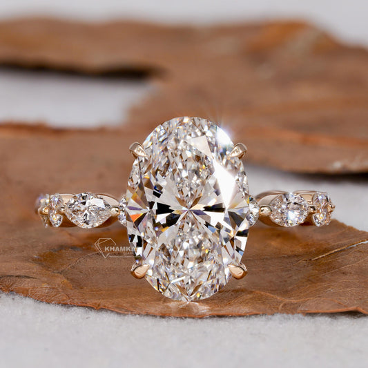 Engagement ring with yellow gold band, oval clear center stone, marquise and round side stones, front view
