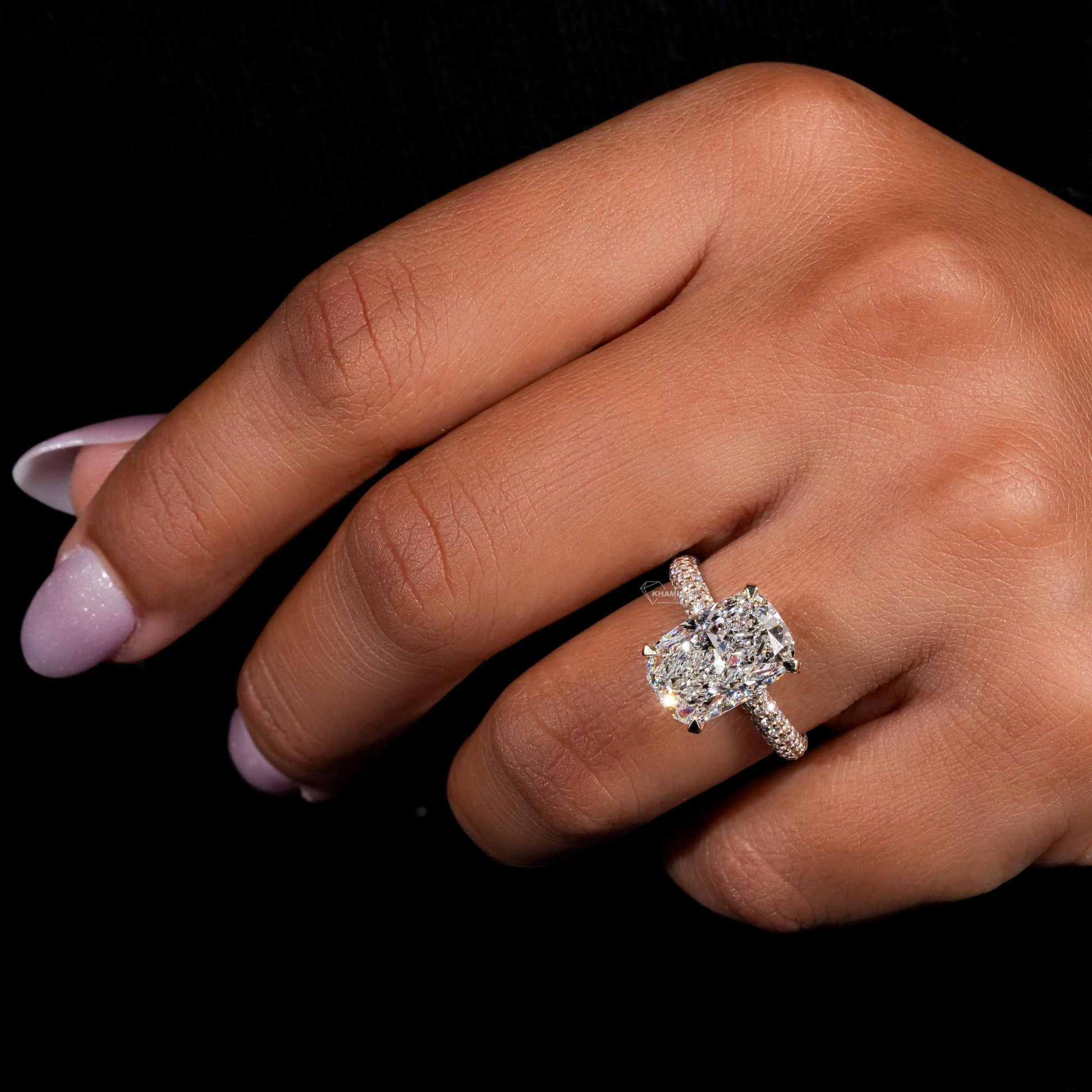 Engagement ring with rectangular clear gemstone, yellow metal pavé band, four-prong setting, worn on finger, angled view
