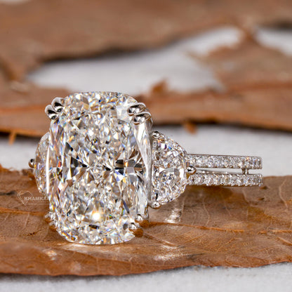 Engagement ring with white metal split shank, elongated cushion-cut clear center stone, oval side stones, angled front view
