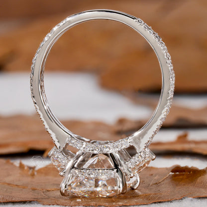 Engagement ring with white metal split shank, elongated cushion-cut clear center stone, open gallery design, rear view

