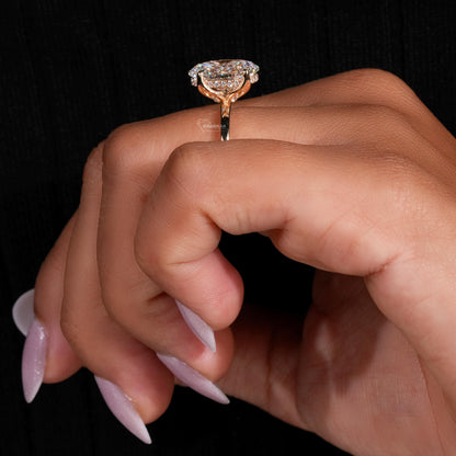 Engagement ring with yellow metal band, oval solitaire gemstone, worn on finger, side profile view
