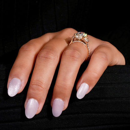 Engagement ring with yellow gold band, oval clear center gemstone, marquise side stones, worn on finger, side angle view

