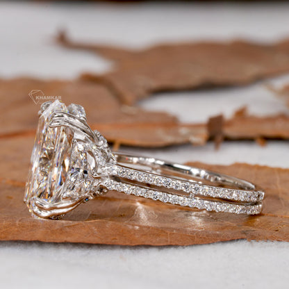 Engagement ring with white metal split shank, elongated cushion-cut clear center stone, oval side stones, side profile view
