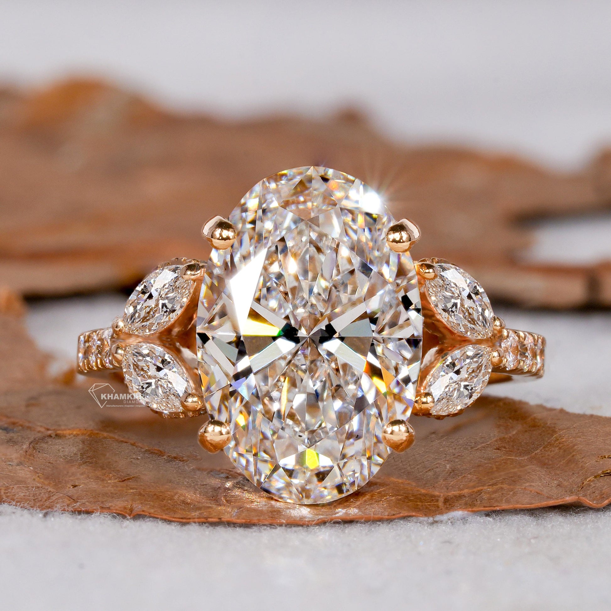 Engagement ring with yellow gold band, oval clear center gemstone, marquise side stones and pavé shoulders, front view 
