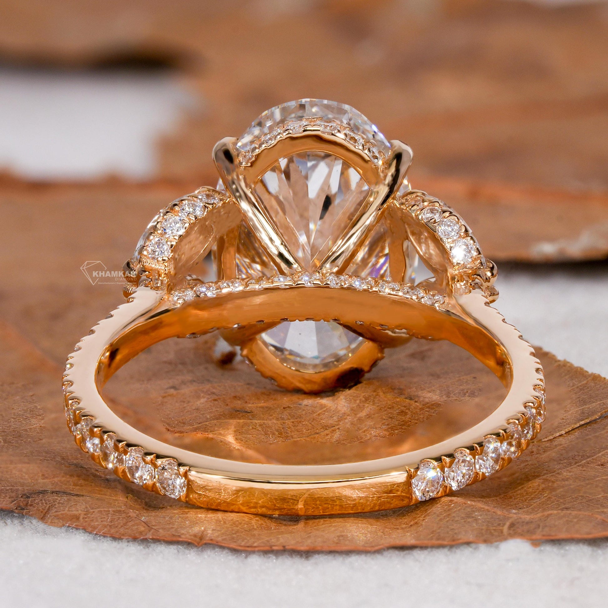 Engagement ring with yellow gold band, oval clear center gemstone, marquise side stones, pavé band, rear gallery view
