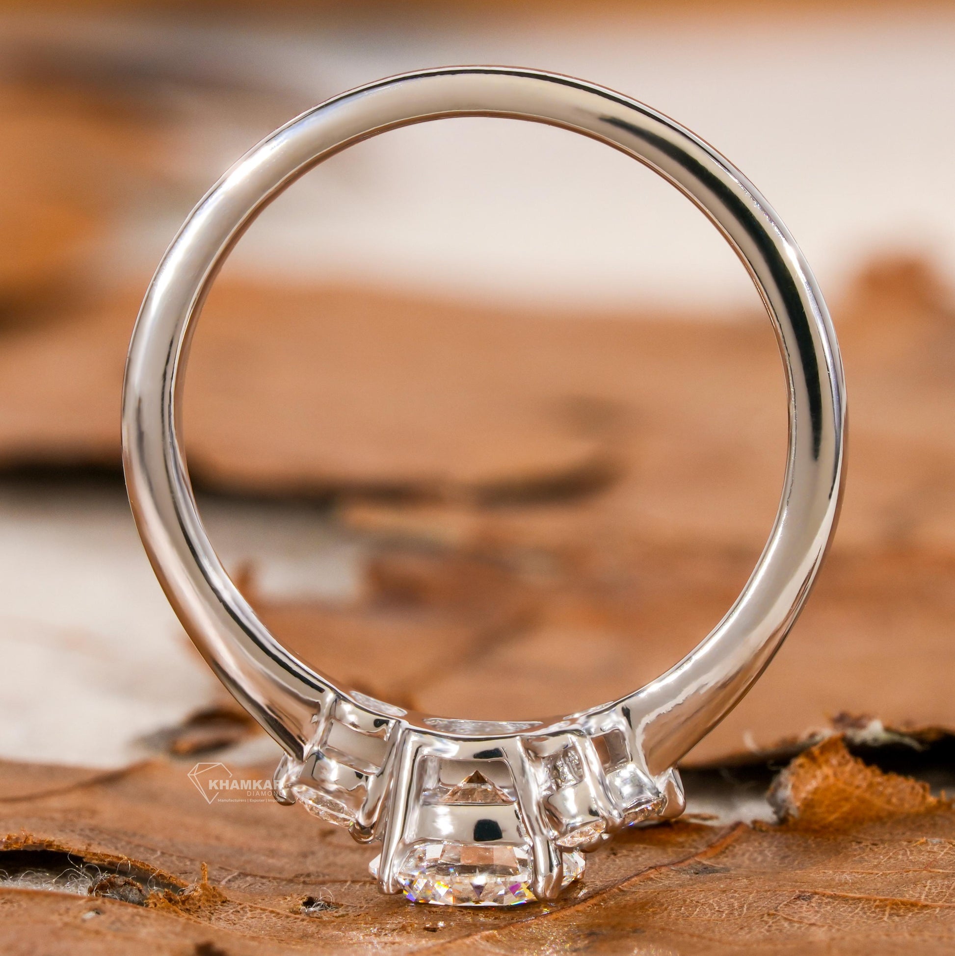 Engagement ring with white metal, round center stone, round accent diamond cluster setting, rear view of band and gallery
