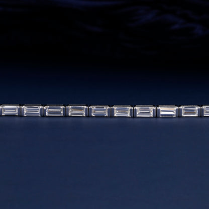 Bracelet with white metal links, rectangular step-cut stones in tennis bracelet design, close-up front detail view on a dark background

