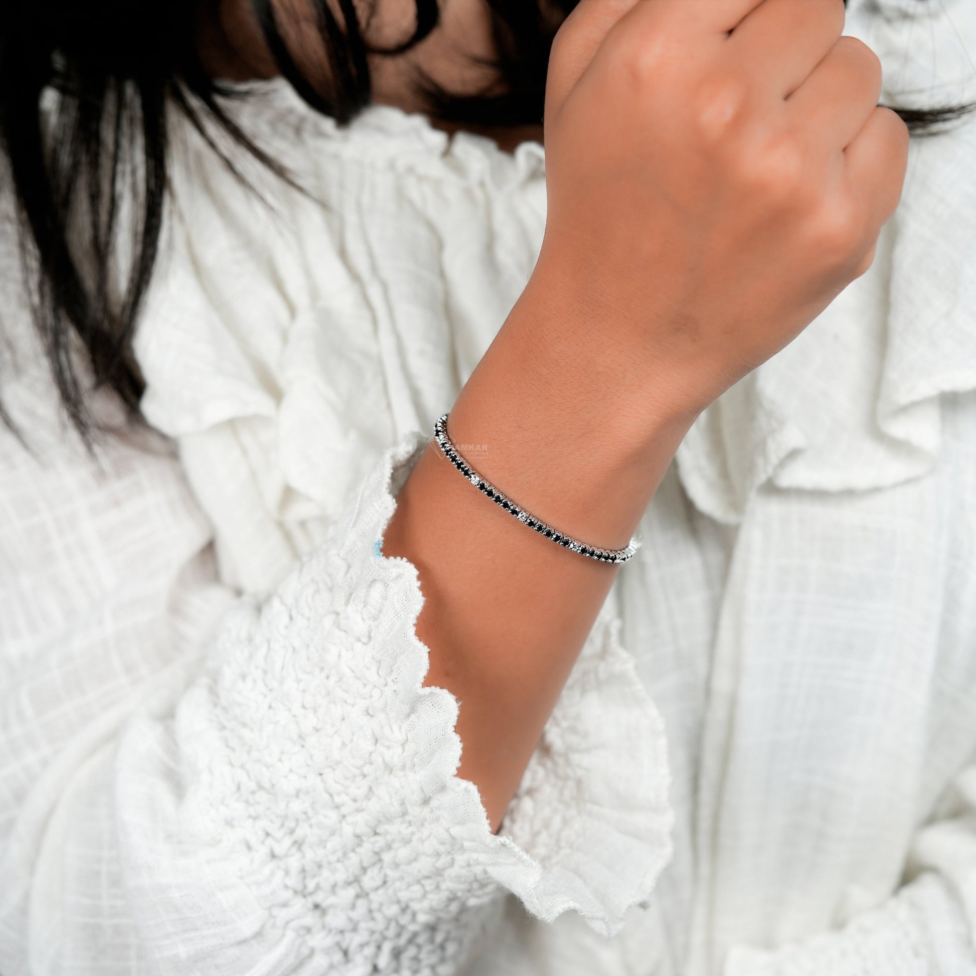 Bracelet with clear round stones in a continuous line setting, worn on wrist, close-up lifestyle view, tennis bracelet jewelry
