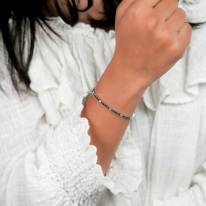 Bracelet with clear round stones in a continuous line setting, worn on wrist, close-up lifestyle view, tennis bracelet jewelry
