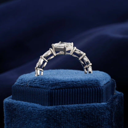 Engagement ring with white metal twisted band, princess-cut center stone, marquise side stones, rear view showing gallery setting on blue velvet display
