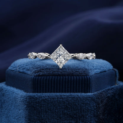 Engagement ring with white metal band, princess-cut center stone, marquise side stones, twisted band design, front view on blue velvet display
