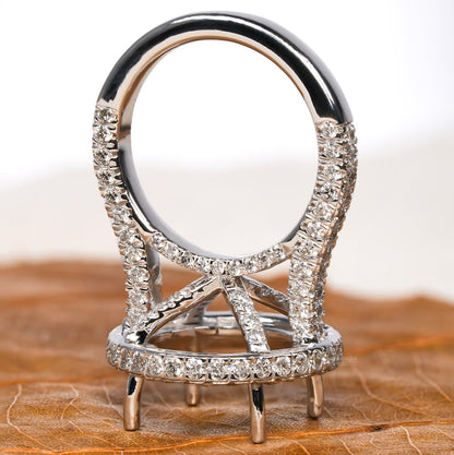 Engagement ring with white metal oval halo setting, pavé split shank, open four-prong center setting, rear view

