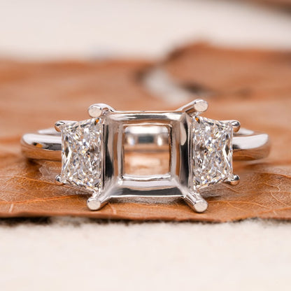 Engagement ring with white metal band, empty four-prong center setting, tapered trapezoid side stones, rear view
