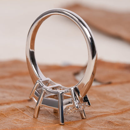 Engagement ring with white metal band, empty rectangular center setting, four-prong design, open gallery, rear angled view
