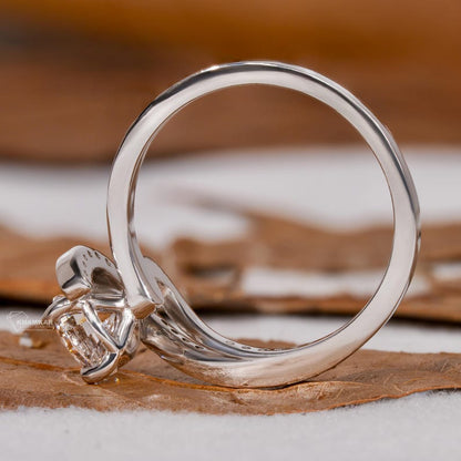 Engagement ring with round center stone, white metal twisted bypass setting, side profile view

