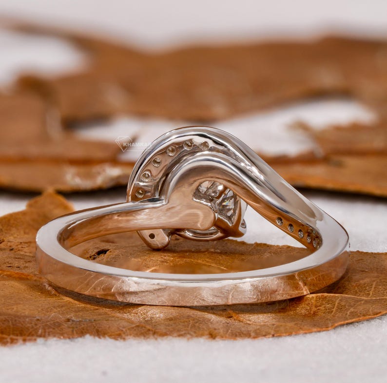 Engagement ring with round center stone, white metal swirl design, open gallery setting, rear view

