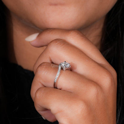 Engagement ring with round center stone, white metal pavé band, worn on hand, side angle view
