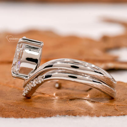 Engagement ring set in white metal with oval solitaire diamond and curved pavé wedding band, side profile view