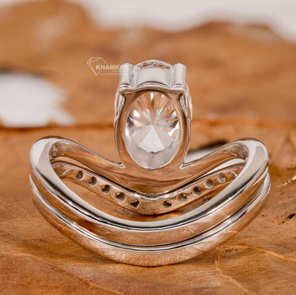 Engagement ring set in white metal with oval solitaire diamond and curved pavé wedding band, rear view showing open gallery and band details
