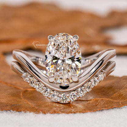 Engagement ring set with oval solitaire diamond and curved pavé wedding band in white metal, front view