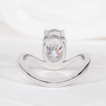 Engagement ring with oval cut clear center stone, silver tone curved solitaire band, open gallery setting, rear view