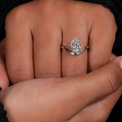 Engagement ring with oval cut clear center stone, silver tone curved solitaire band, worn on hand, front view