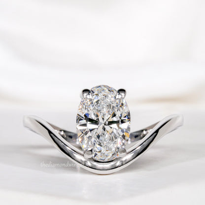 Engagement ring with oval cut clear center stone, silver tone band with four-prong setting, front close-up view