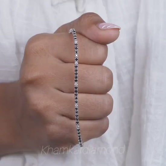 Bracelet with clear round stones in a continuous line setting, held across hand, close-up lifestyle view, tennis bracelet jewelry

