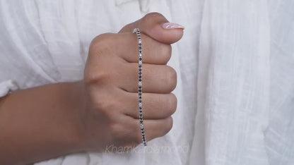 Bracelet with clear round stones in a continuous line setting, held across hand, close-up lifestyle view, tennis bracelet jewelry
