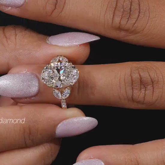 Engagement ring with yellow gold band, four round clear center gemstones in floral cluster design, worn on finger, front view 
