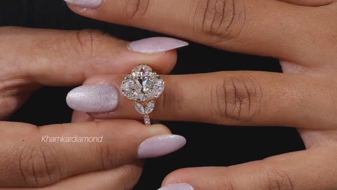Engagement ring with yellow gold band, four round clear center gemstones in floral cluster design, worn on finger, front view 
