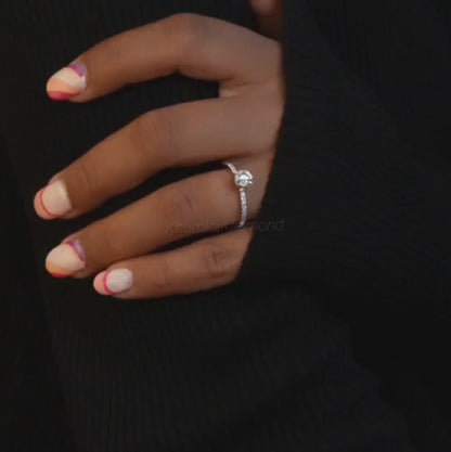 Engagement ring with round clear center stone, white metal pavé band, worn on hand, front view
