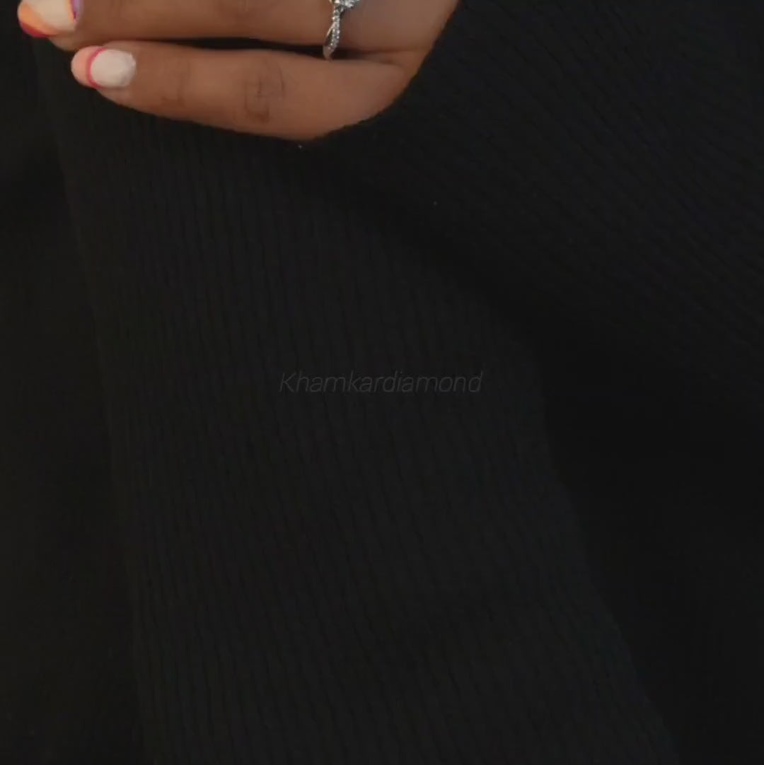 Ring with round clear center stone, twisted white metal band with pavé-set shoulders, worn on a hand, front view
